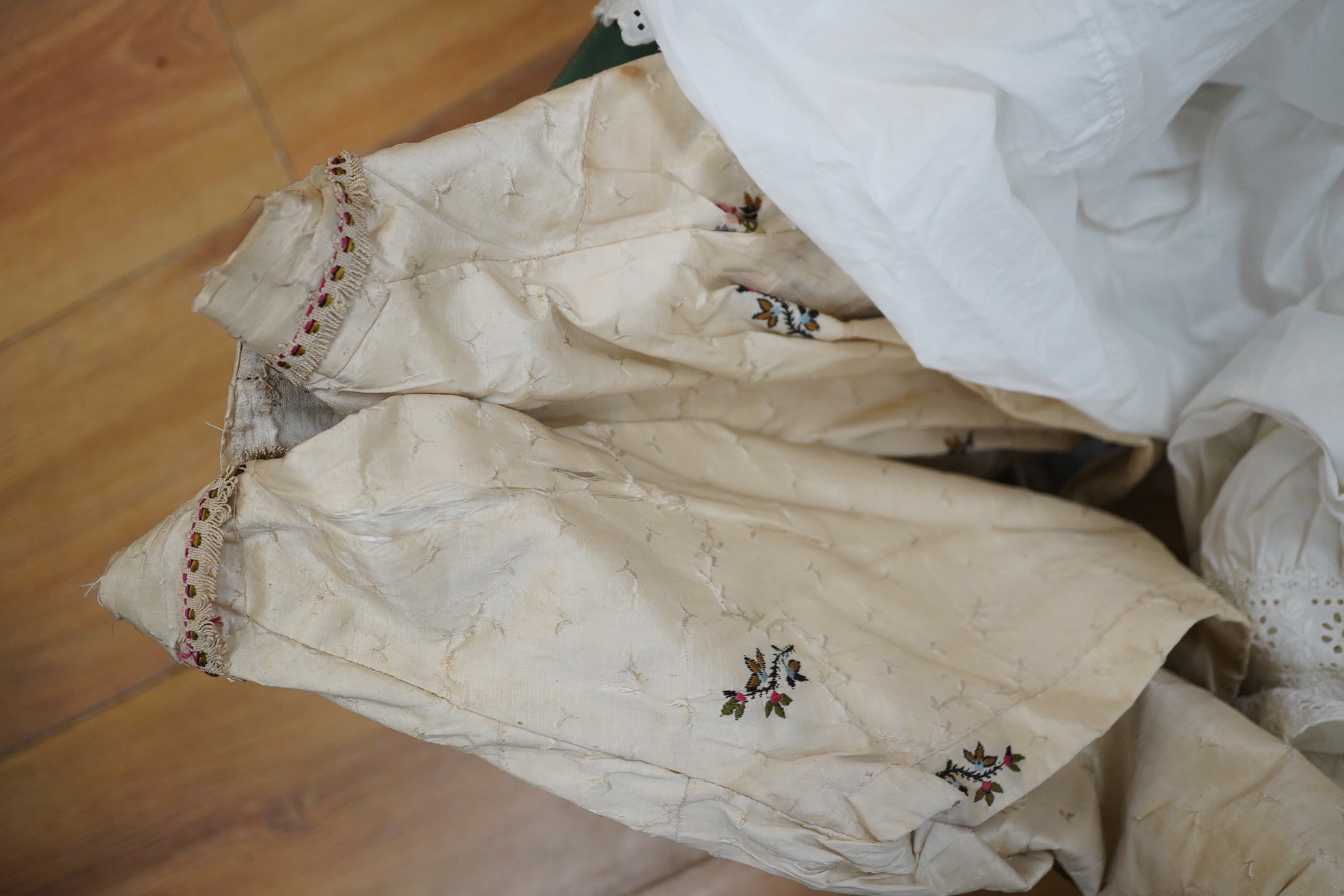 An 18th century cream silk sprig embroidered child’s bodice (unfinished) with two later 19th century cotton long sleeve blouses and four embroidery anglaise edged chemise/bloomers. Condition - the child’s silk bodice nee